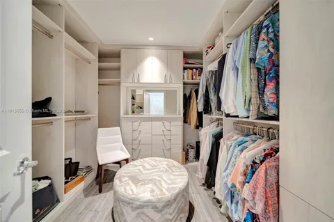 a view of walk in closet with clothes and shoes