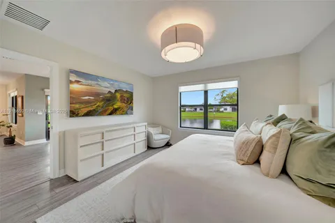 a spacious bedroom with a bed and a flat screen television