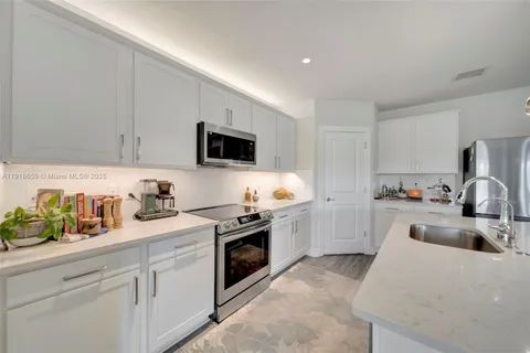a kitchen with a sink a stove and cabinets