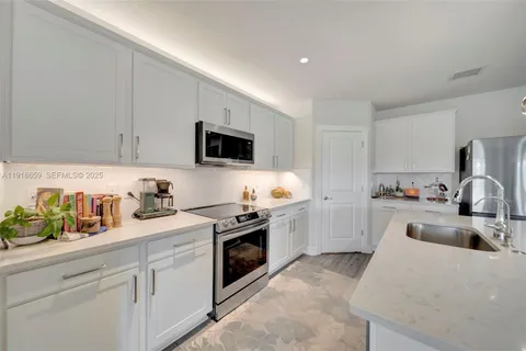 a kitchen with a sink a stove and cabinets