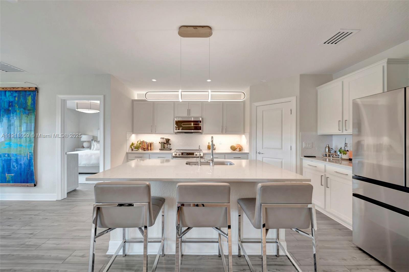 2941 Shortleaf Avenue Lauderdale Lakes, FL 33311 - Photo 23 of 47 a kitchen with a dining table chairs refrigerator and cabinets