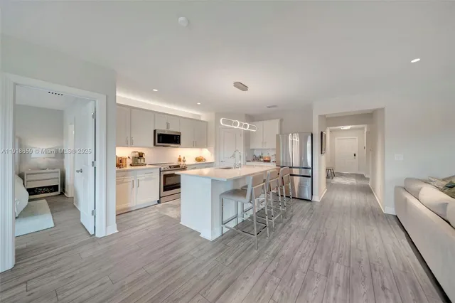 a view of kitchen with sink microwave and refrigerator