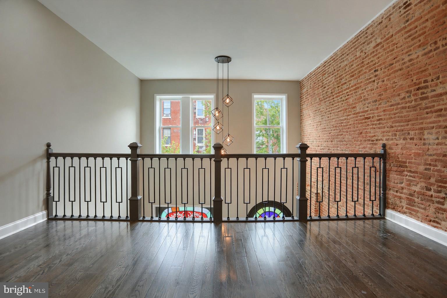1811 Madison Avenue Baltimore, MD 21217 - Photo 14 of 37 an empty room with wooden floor and windows