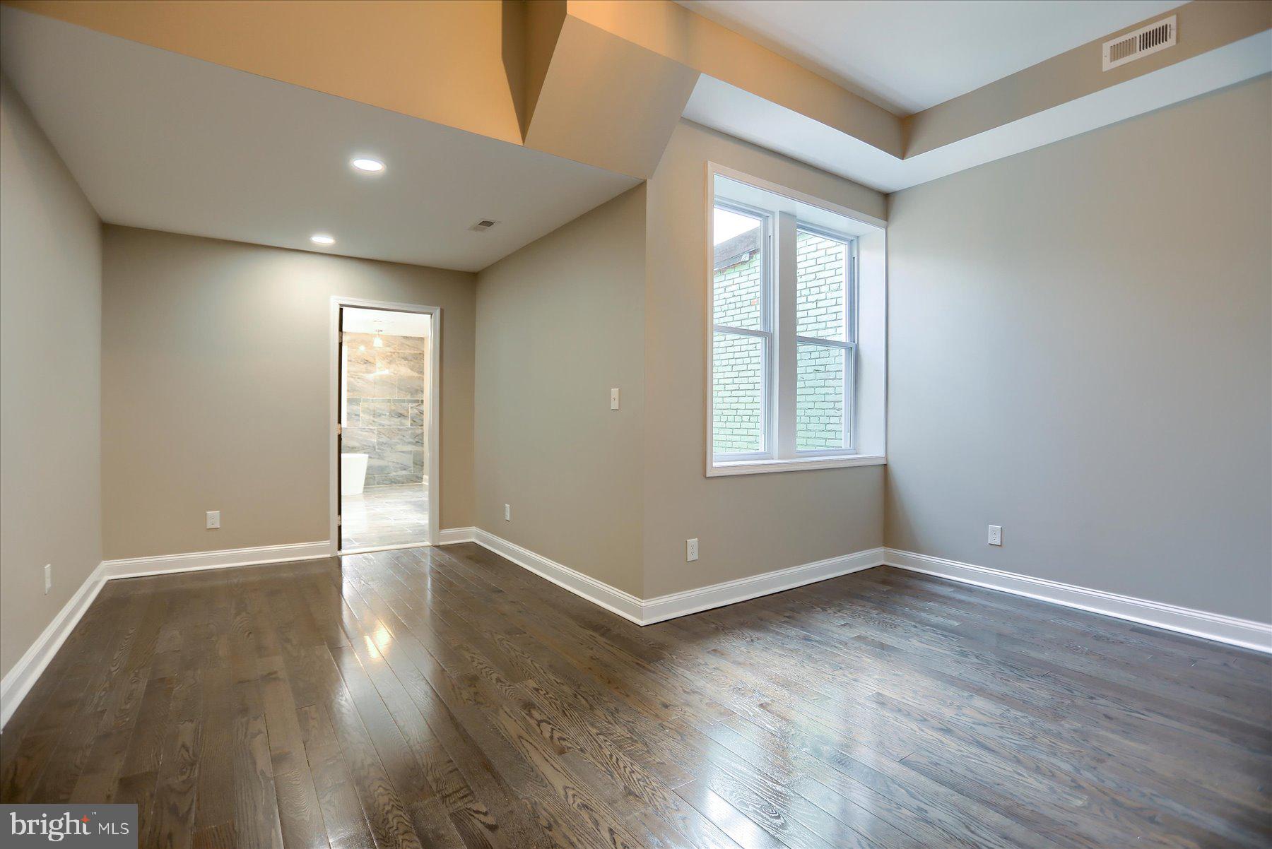 1811 Madison Avenue Baltimore, MD 21217 - Photo 16 of 37 a view of an empty room with wooden floor and a window