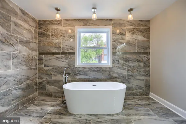a bathroom with a sink a toilet a mirror and shower