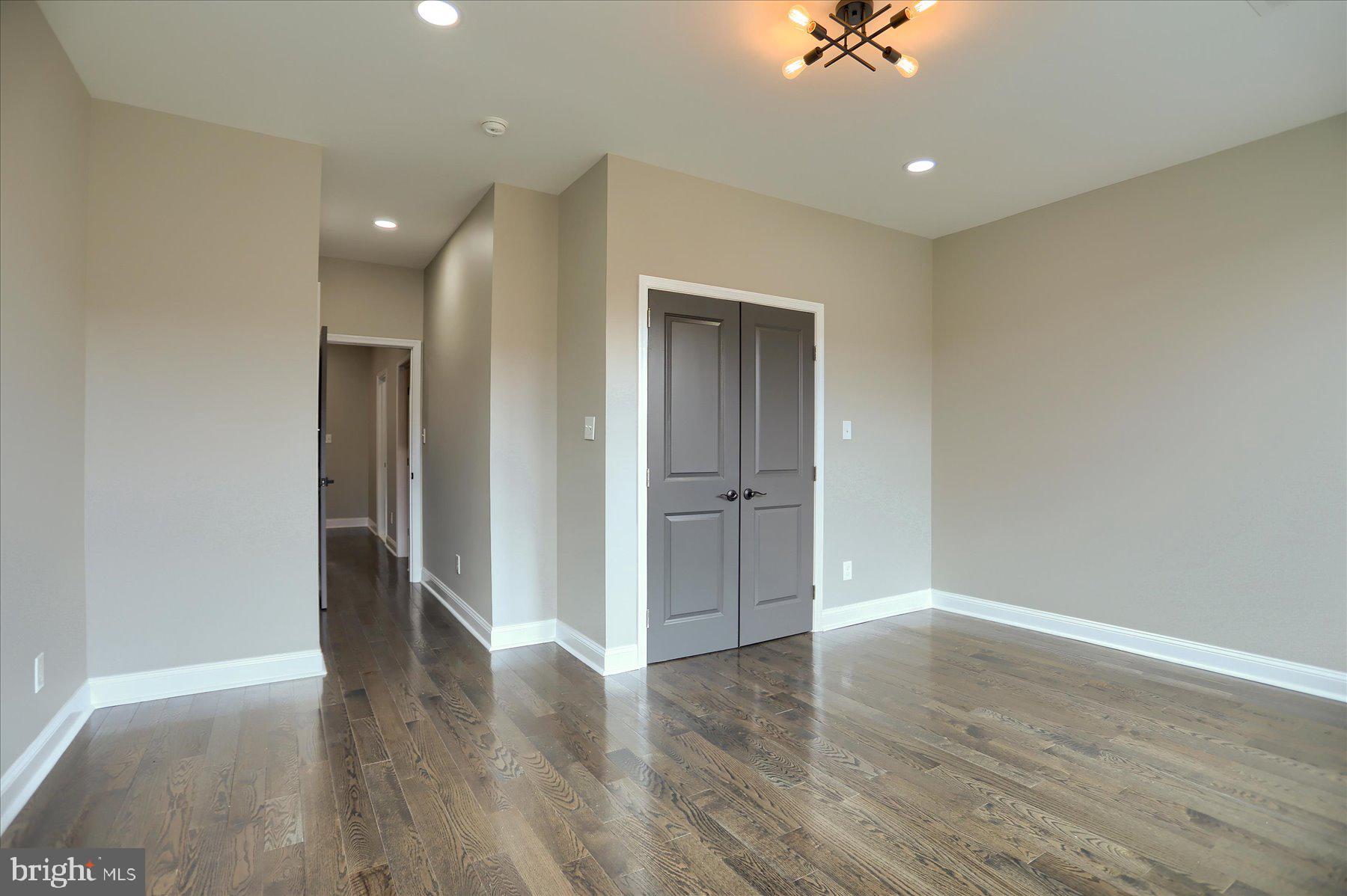 1811 Madison Avenue Baltimore, MD 21217 - Photo 23 of 37 a view of an empty room with a ceiling fan window and wooden floor