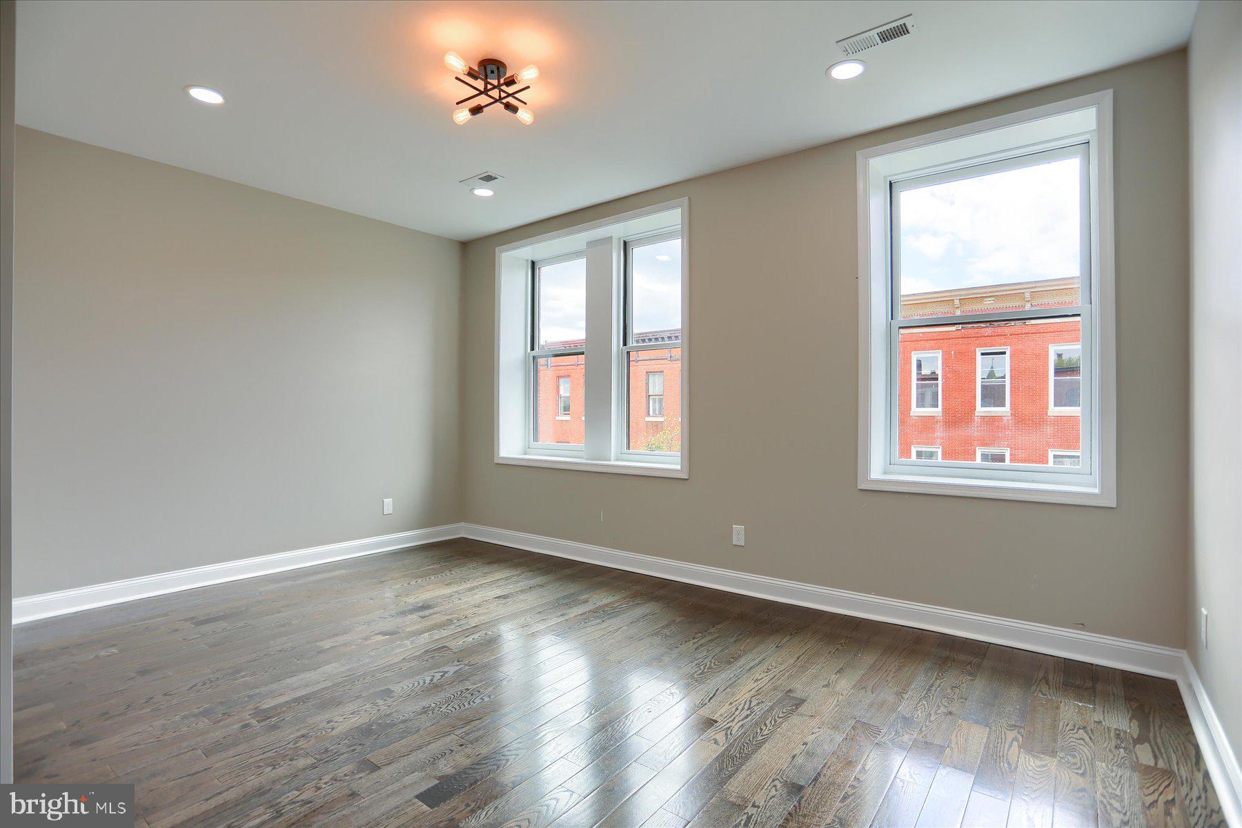 1811 Madison Avenue Baltimore, MD 21217 - Photo 24 of 37 a view of an empty room with wooden floor and a window