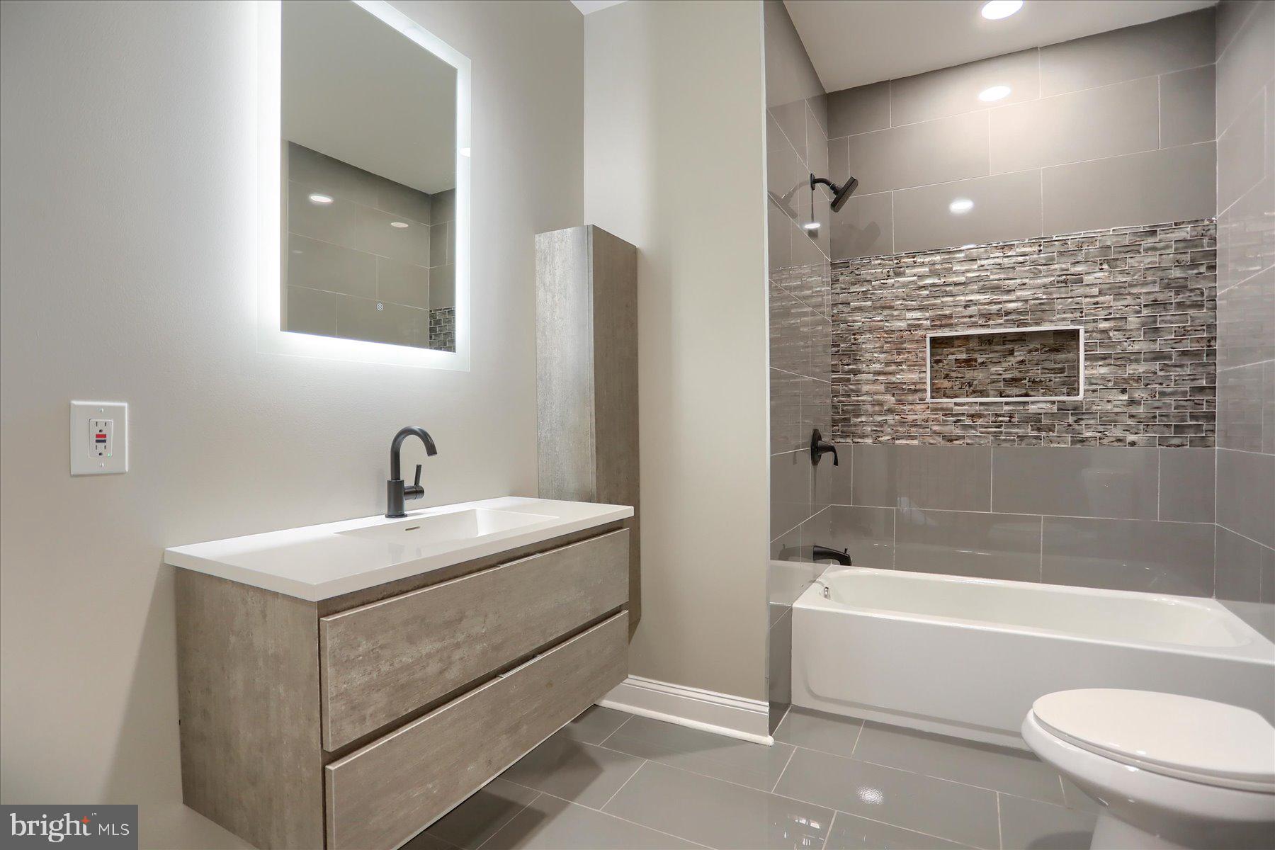 1811 Madison Avenue Baltimore, MD 21217 - Photo 25 of 37 a bathroom with a sink a toilet and shower
