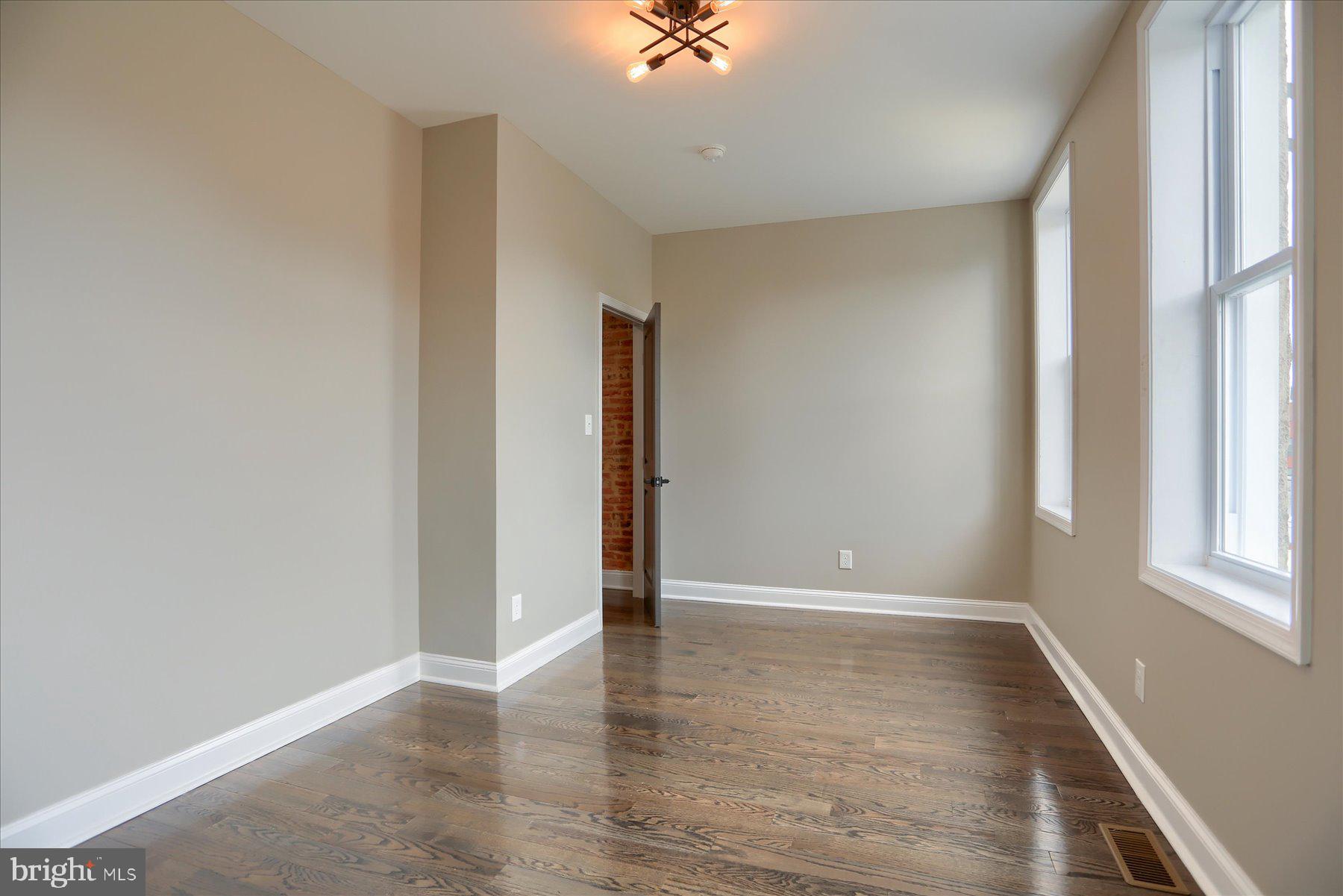 1811 Madison Avenue Baltimore, MD 21217 - Photo 26 of 37 wooden floor in an empty room with a window