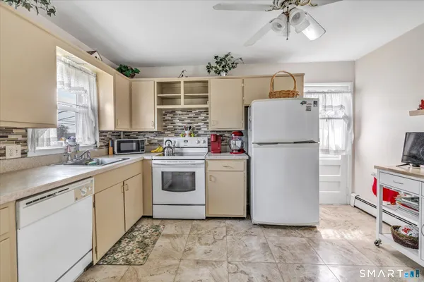 a kitchen with stainless steel appliances kitchen island granite countertop a stove a sink a dining table and chairs