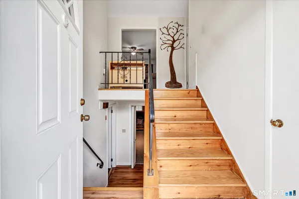 a view of a hallway with furniture and a chandelier