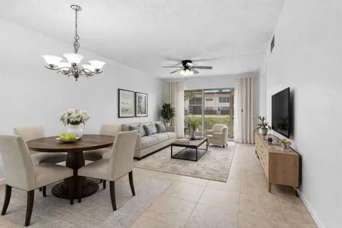 a living room with furniture a chandelier and a flat screen tv