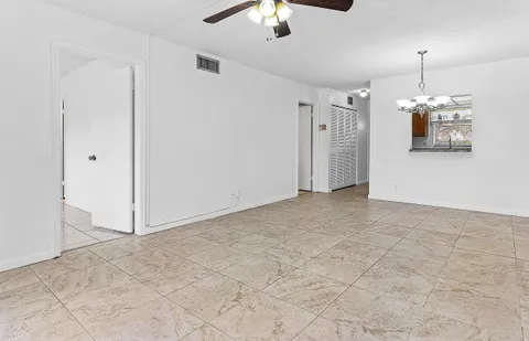 a view of a hallway with a chandelier fan