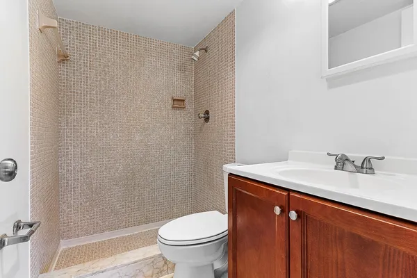 a bathroom with a granite countertop sink toilet and shower