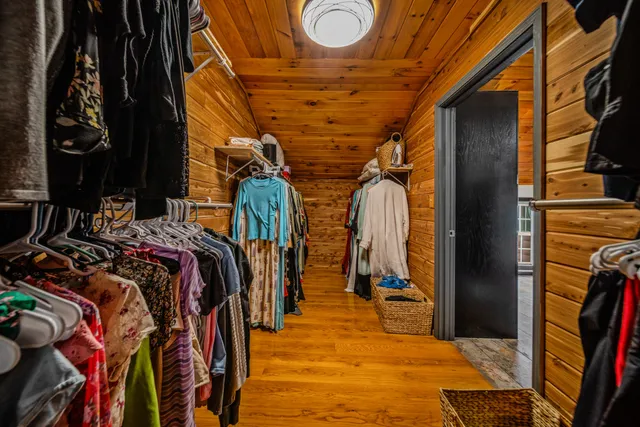 a view of walk in closet with clothes and shoes