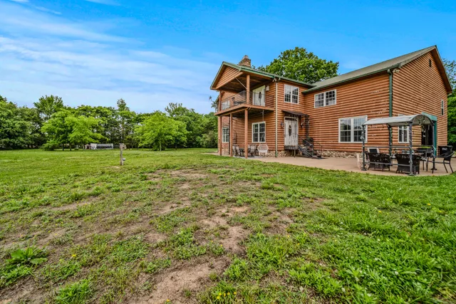 a view of a house with a big yard plants and large trees