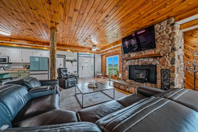 a living room with furniture a fireplace and a large window