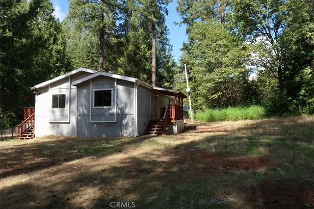 a view of a house with backyard and trees
