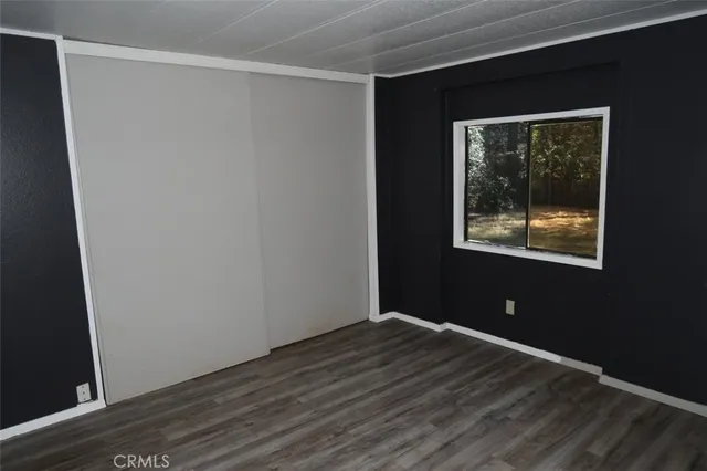an empty room with wooden floor and closet