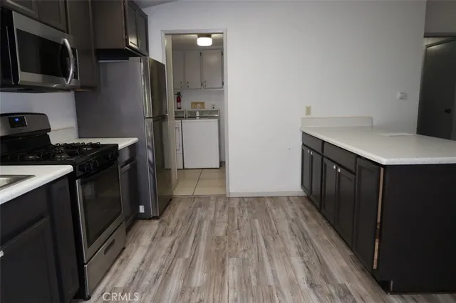 a kitchen with a refrigerator stove and wooden cabinets