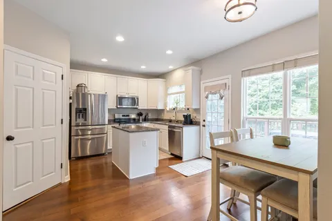 a kitchen with refrigerator cabinets and wooden floor