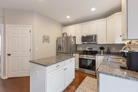a kitchen with granite countertop a sink stove and refrigerator
