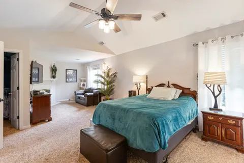 a living room with a bed furniture and a flat screen tv