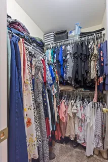 a view of walk in closet with clothes and shoes
