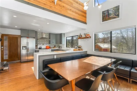 a kitchen with stainless steel appliances granite countertop a stove a refrigerator a kitchen island with chairs and wooden floor