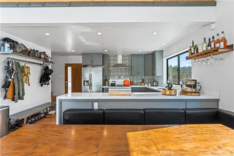 a living room with stainless steel appliances kitchen island granite countertop a couch and cabinets