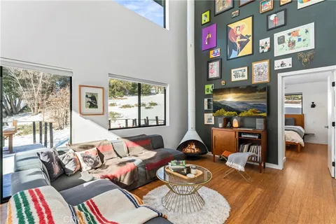 a living room with furniture fireplace and wooden floor