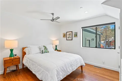 a bedroom with a bed and wooden floor