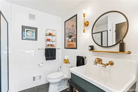 a bathroom with a sink mirror and toilet