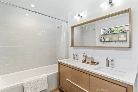 a bathroom with a granite countertop sink a mirror a shower and a bathtub