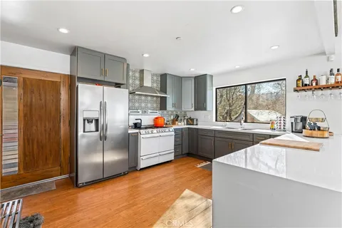 a kitchen with stainless steel appliances a refrigerator a sink dishwasher a stove top oven a refrigerator and cabinets