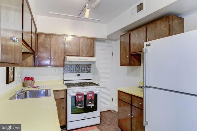 a kitchen with stainless steel appliances granite countertop a refrigerator and a stove