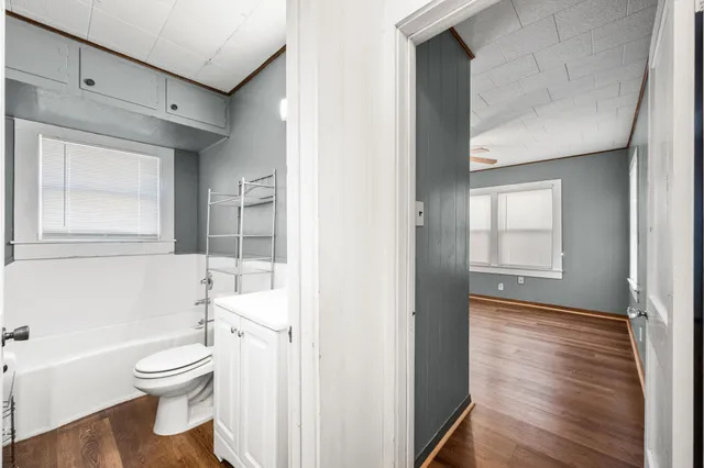 a bathroom with a toilet a bath tub and a window