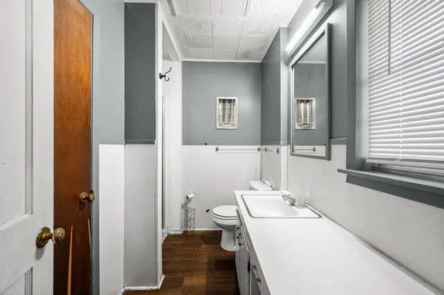 a bathroom with a sink a toilet a mirror and shower