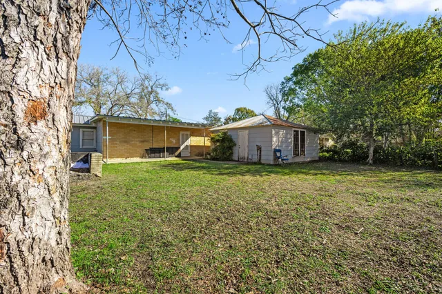 a front view of house with yard and trees around