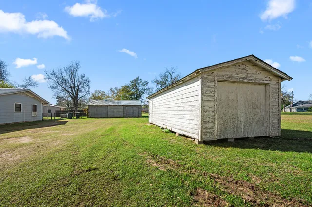 a view of backyard of house with wooden fence