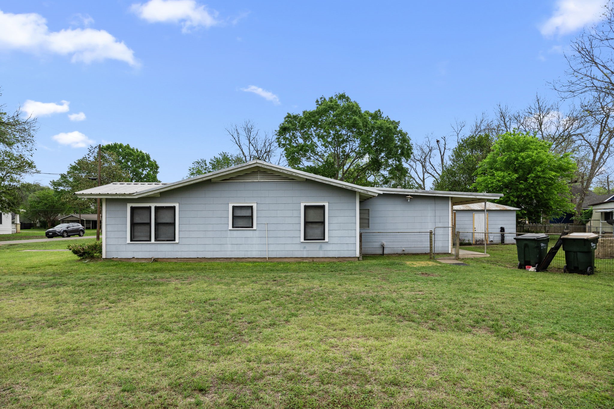 209 3rd Avenue Columbus, TX 78934 - Photo 6 of 34 a house that is sitting in the grass with large trees and plants