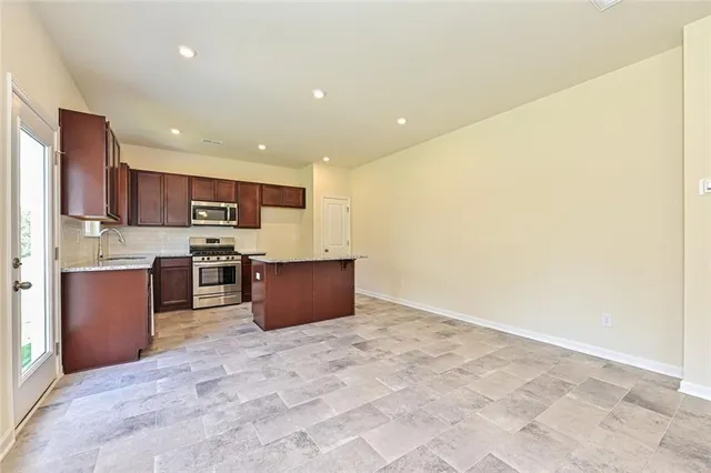 a large kitchen with stainless steel appliances cabinets a sink and a counter top