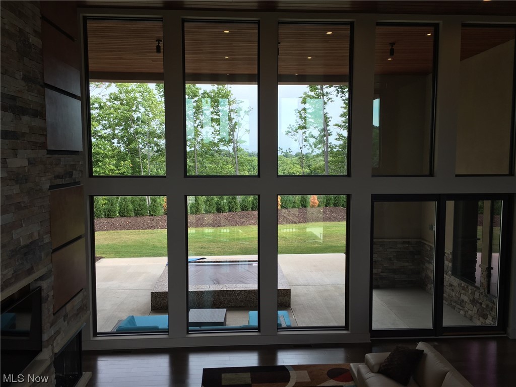 2300 Rivers Edge Drive Willoughby, OH 44094 - Photo 5 of 29 Great Room Wall Of Windows with customized shades overlooking back patio with cedar ceiling flowing from inside to outdoors