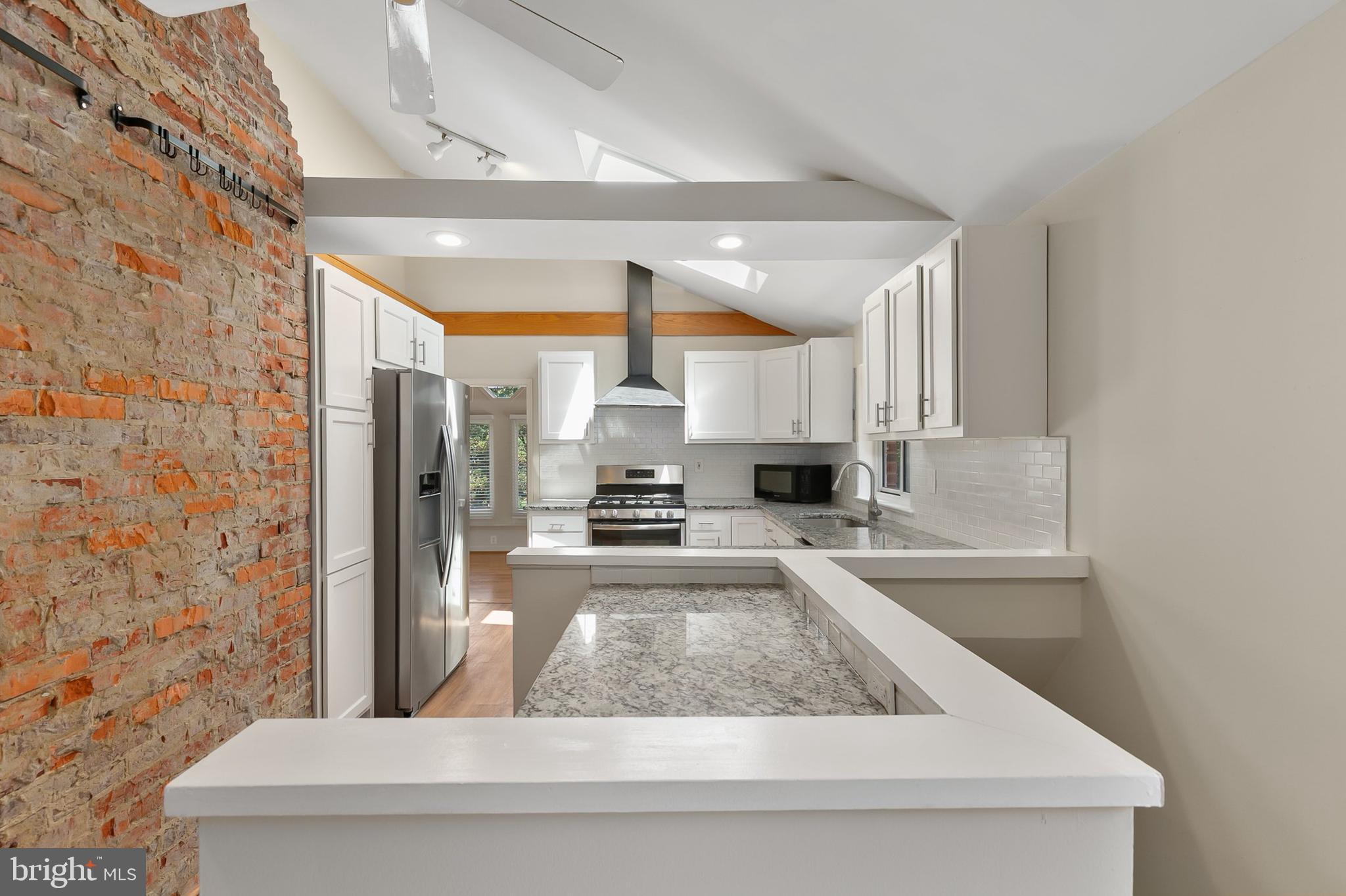 10601 Kinloch Road Silver Spring, MD 20903 - Photo 13 of 47 a kitchen with stainless steel appliances granite countertop a refrigerator a sink and white cabinets with wooden floor