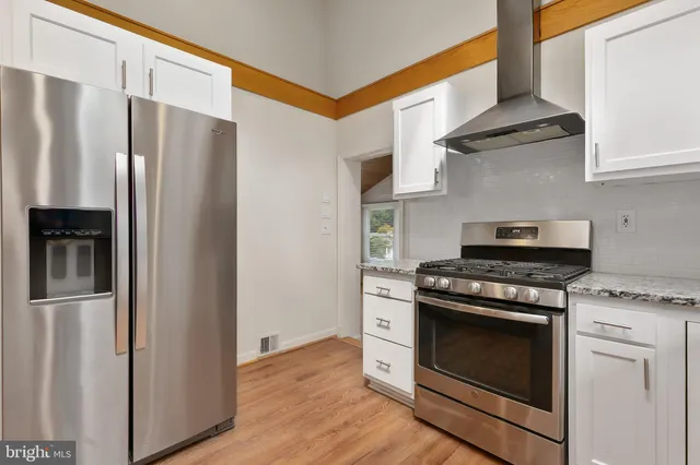 a kitchen with stainless steel appliances granite countertop a stove and a refrigerator
