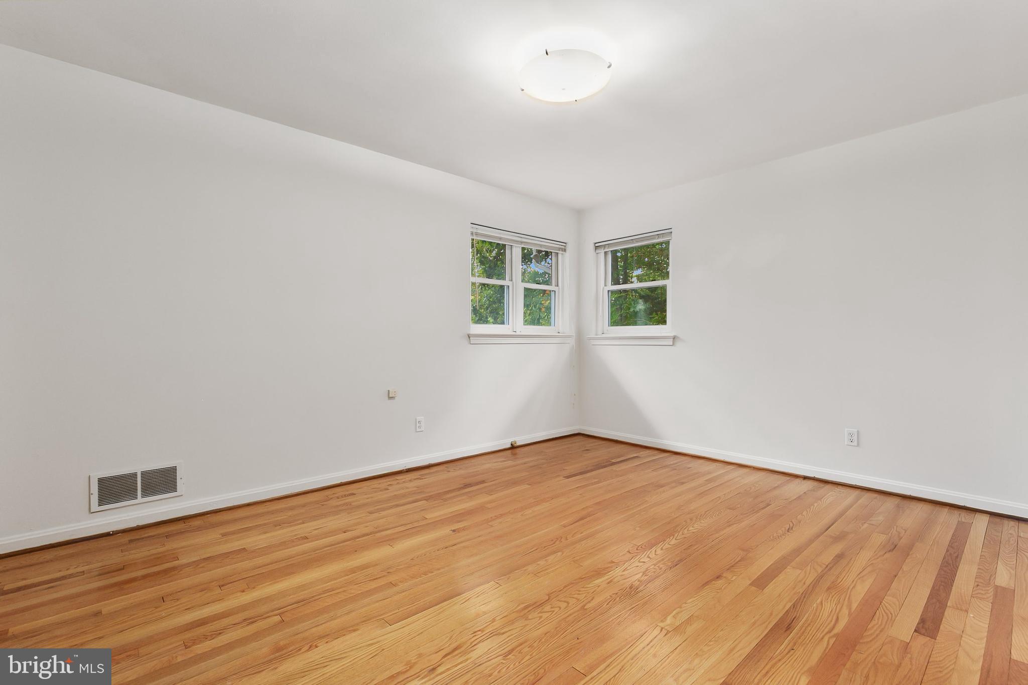 10601 Kinloch Road Silver Spring, MD 20903 - Photo 25 of 47 an empty room with wooden floor and windows