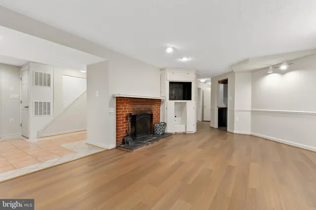 a view of an empty room with a fireplace and a window