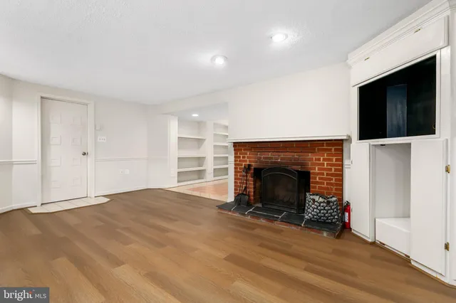 a view of an empty room with a fireplace and a window