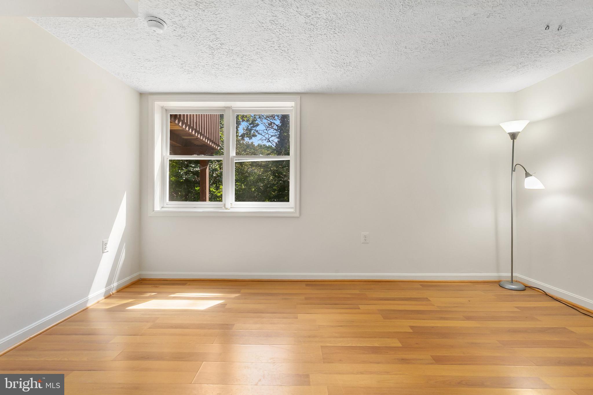10601 Kinloch Road Silver Spring, MD 20903 - Photo 32 of 47 a view of an empty room with wooden floor and a window
