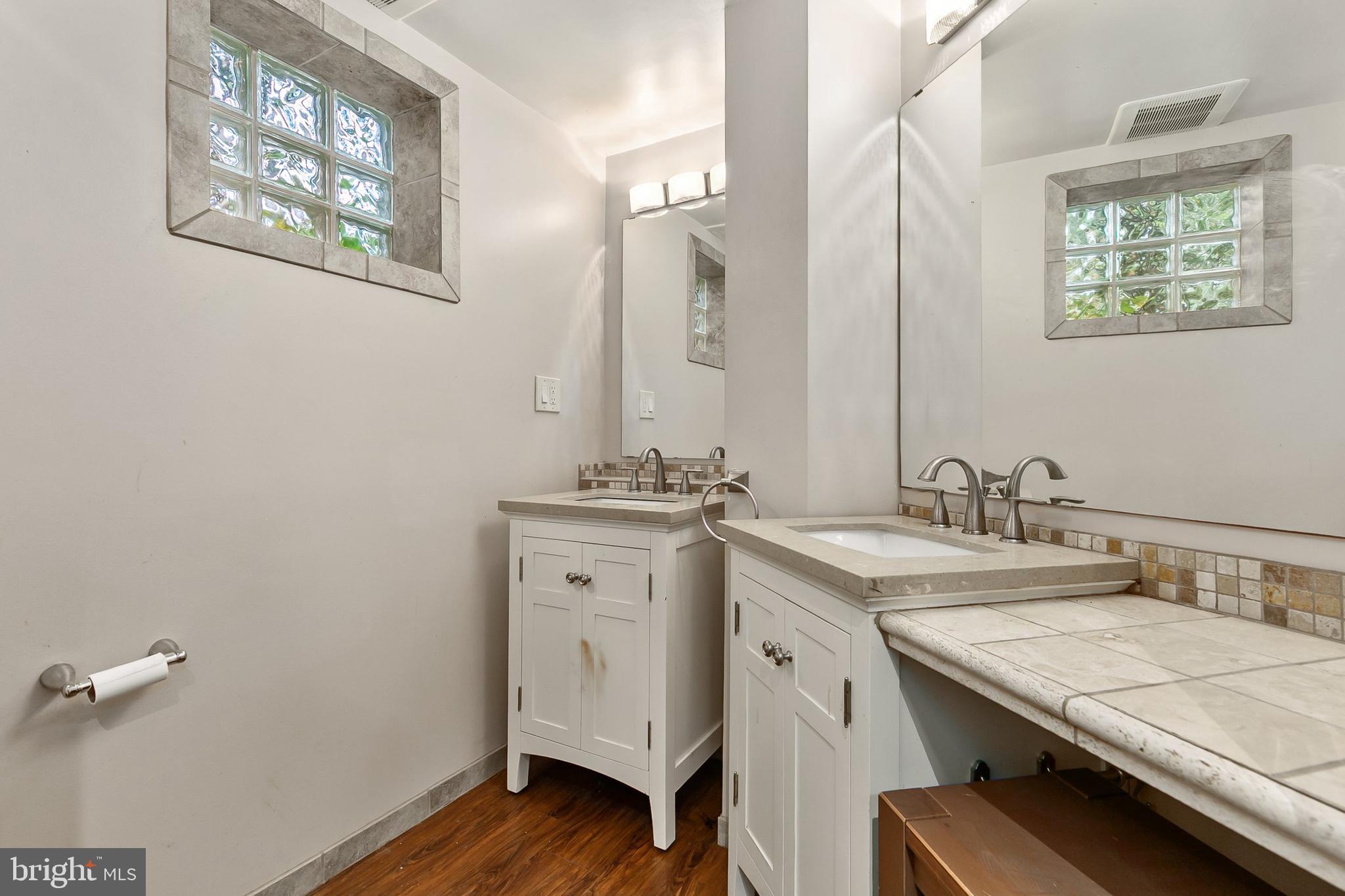 10601 Kinloch Road Silver Spring, MD 20903 - Photo 33 of 47 a bathroom with a granite countertop sink a mirror and a window